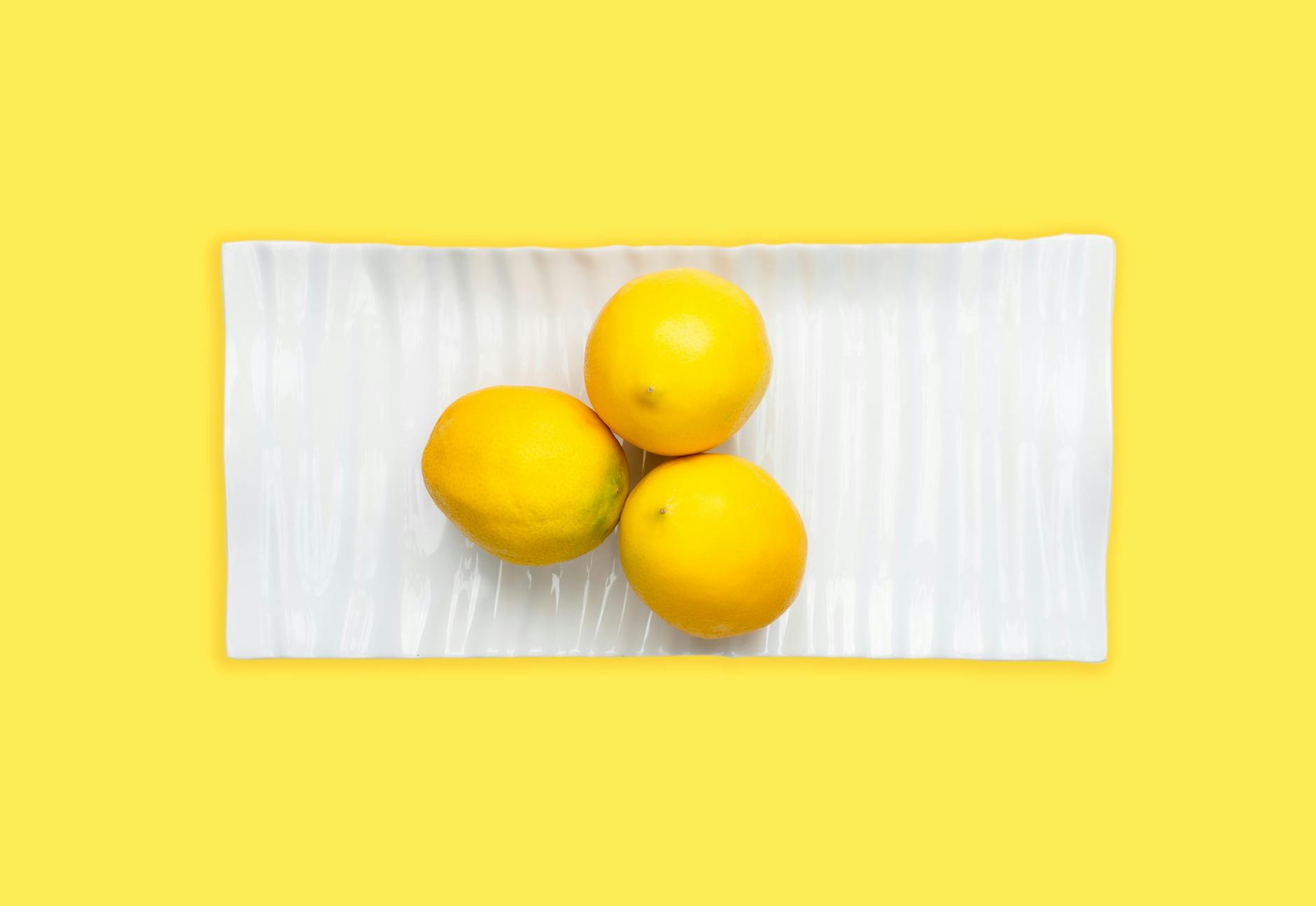 Hands holding a sleek blue lemon vibrator against a purple background