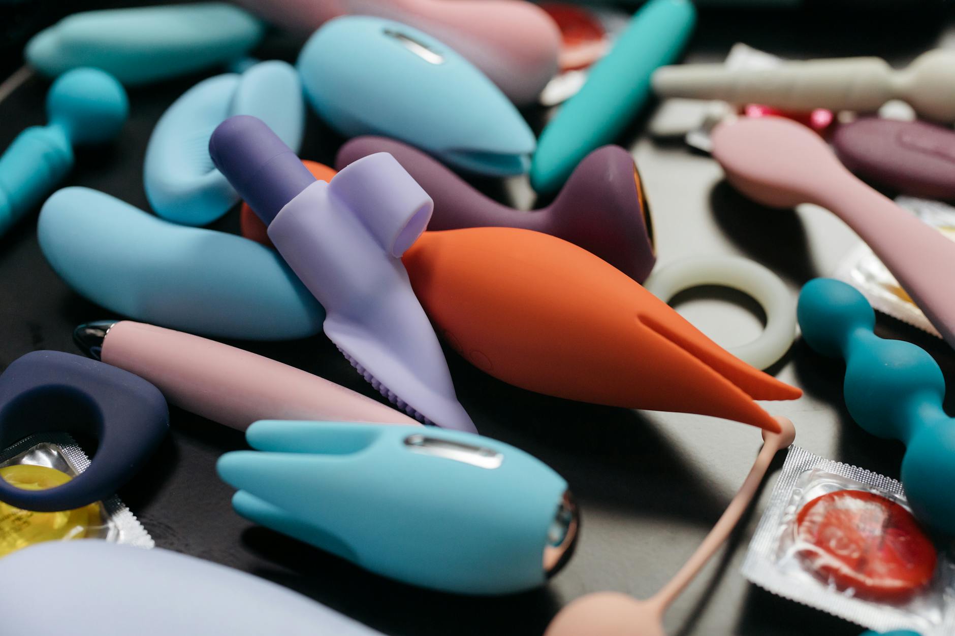 Woman holding vibrators against a colorful background, expression of empowerment