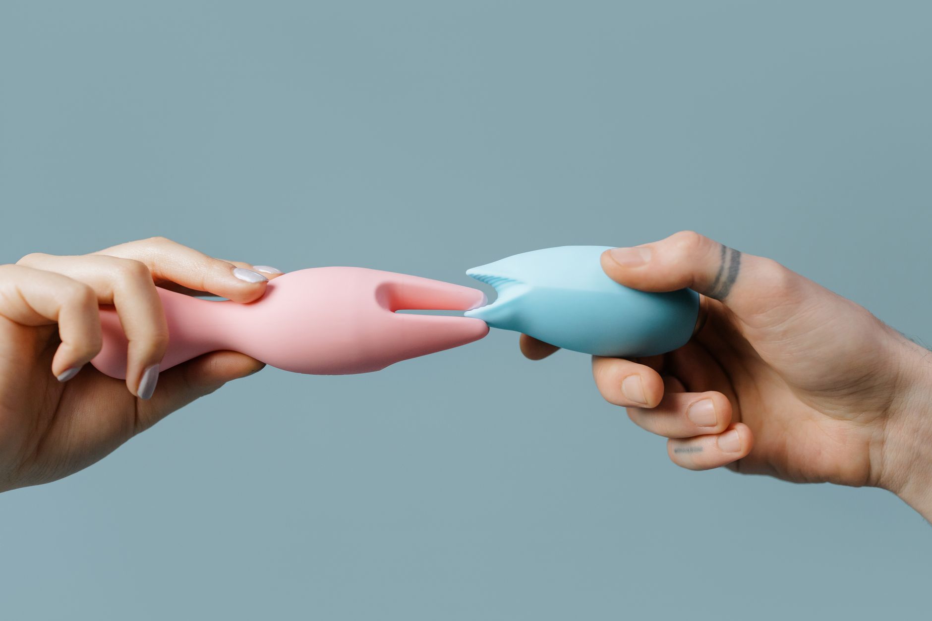 Hands holding colorful silicone vibrators including lemon vibrators for personal pleasure