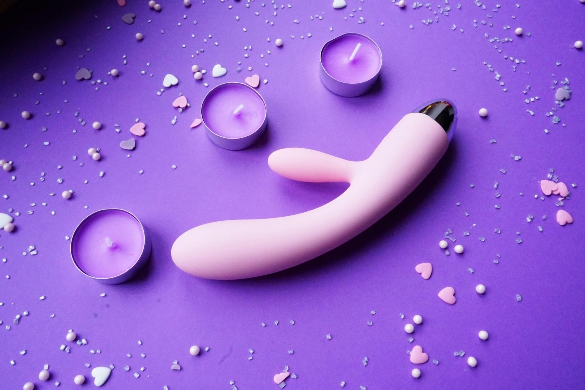 Pink lemon vibrator on purple background with romantic ambiance