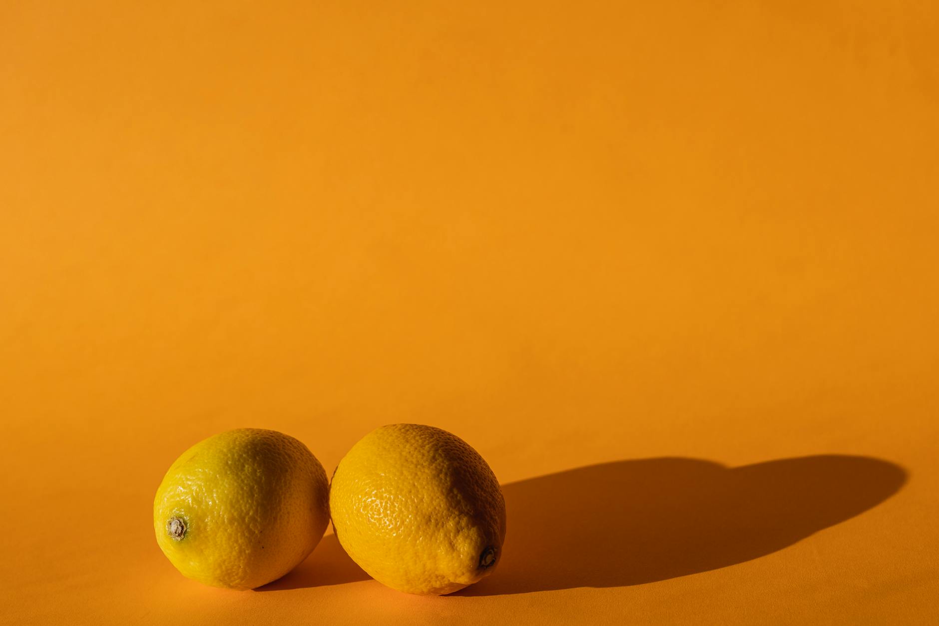 Un vibrateur en silicone jaune vif entouré de bananes pelées sur fond jaune