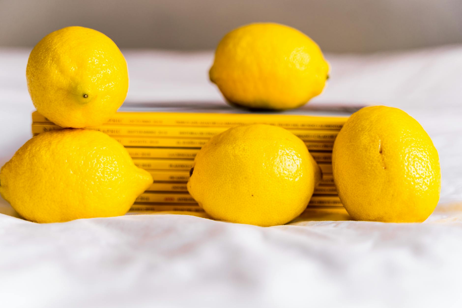 Fresh lemons arranged with stacked books on a white surface, symbolizing returning to basics